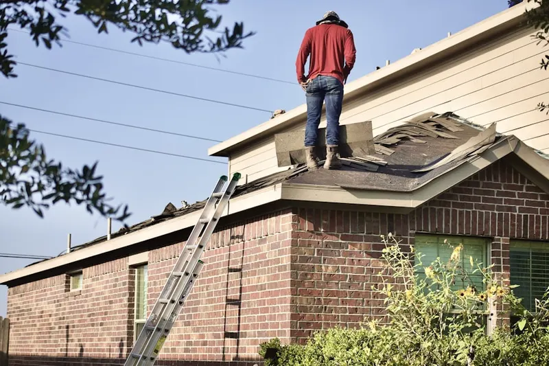 Professional roofer working on a residential roof in Teton Forest